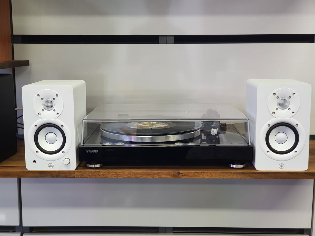 Turntable with white speakers on a wooden shelf